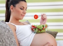 Mujer embarazada comiendo ensalada