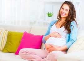 Mujer embarazada sentada en un sofá