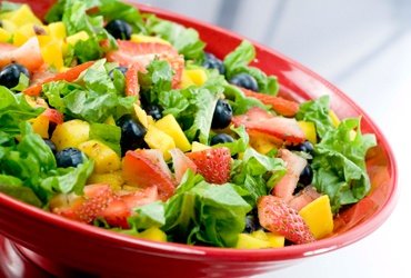 Ensalada de hojas verdes en plato rojo